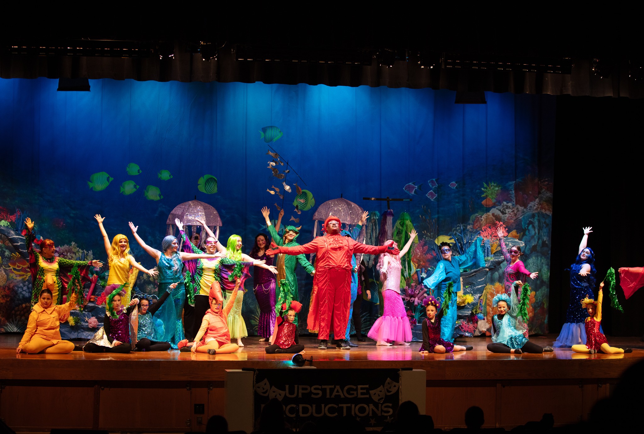 A group of performers moving their arms and singing